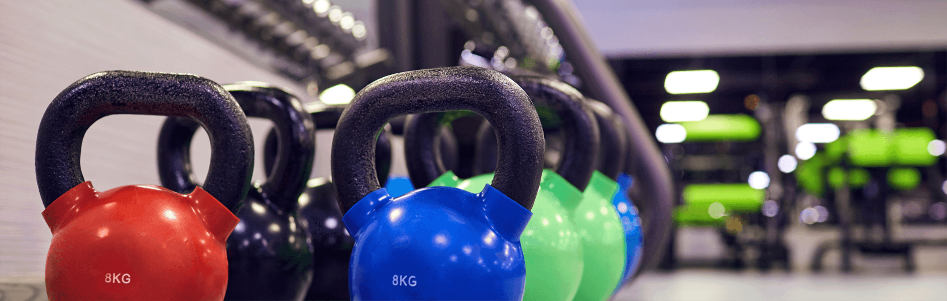 kettle bell weights & dumbells shown at a gym.