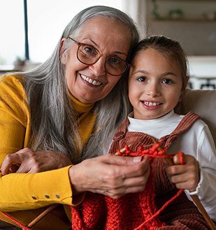 Grandmother and granddaughter learning to knit