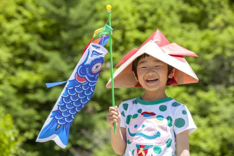 Child holding a koinobori (fish wind sock traditionally associated with Children's Day in Japan)