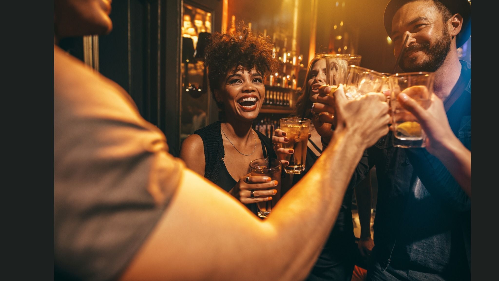 Young professionals laughing and enjoying drinks at a bar