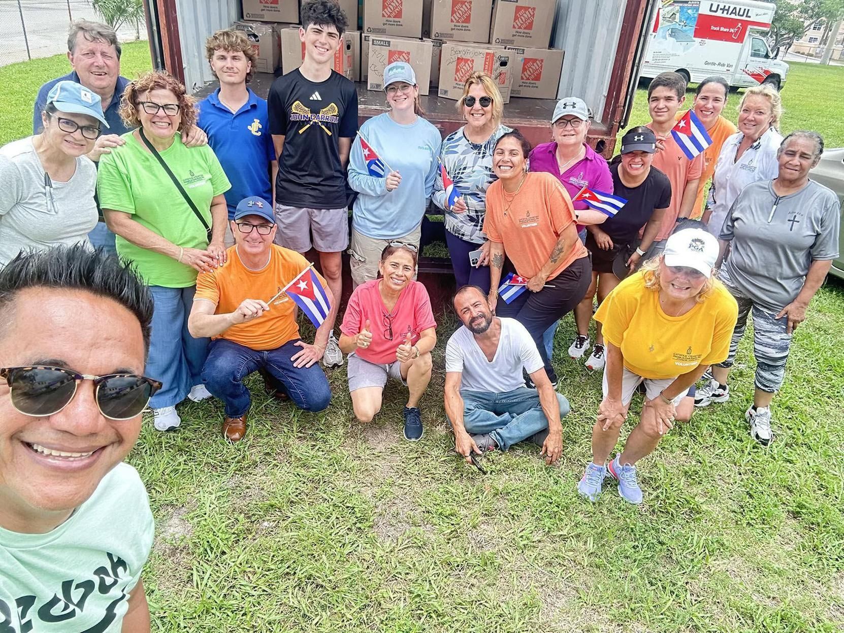 Catholic Charities employees and volunteers pause while packing the shipping container bound for Cuba