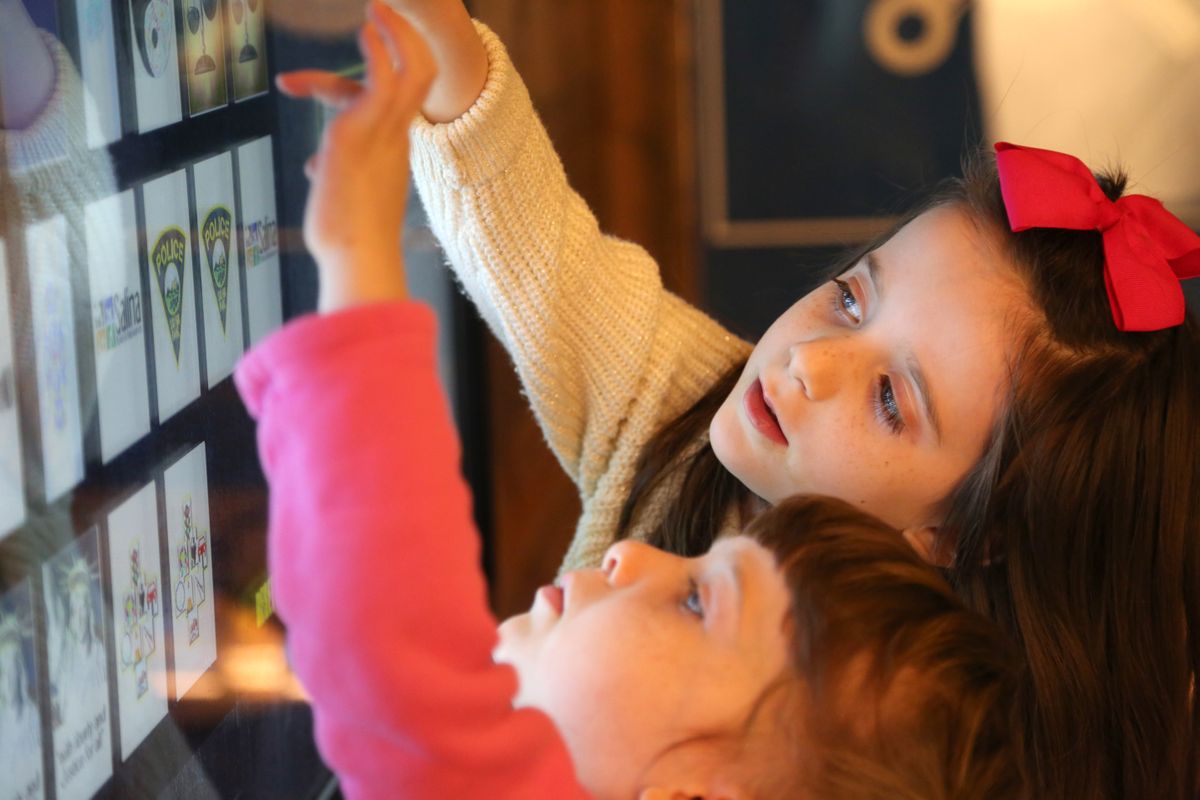 Two girls playing a concentration game in the Smoky Hill Museum exhibit The Curiosity Shop.