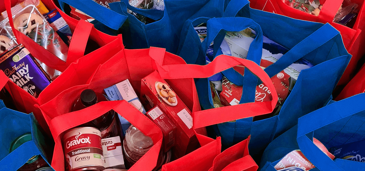 Red and blue tote bags filled with food
