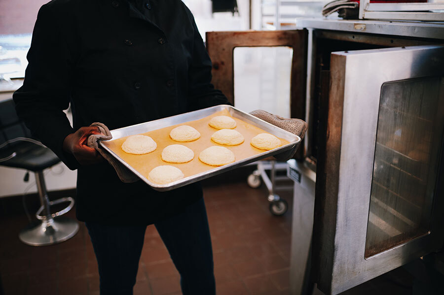 Marcy pulling baked goods out of the oven.