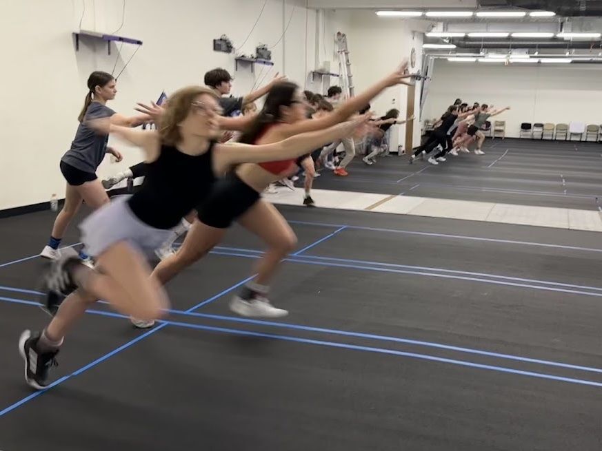 A group of youth fencers fleching