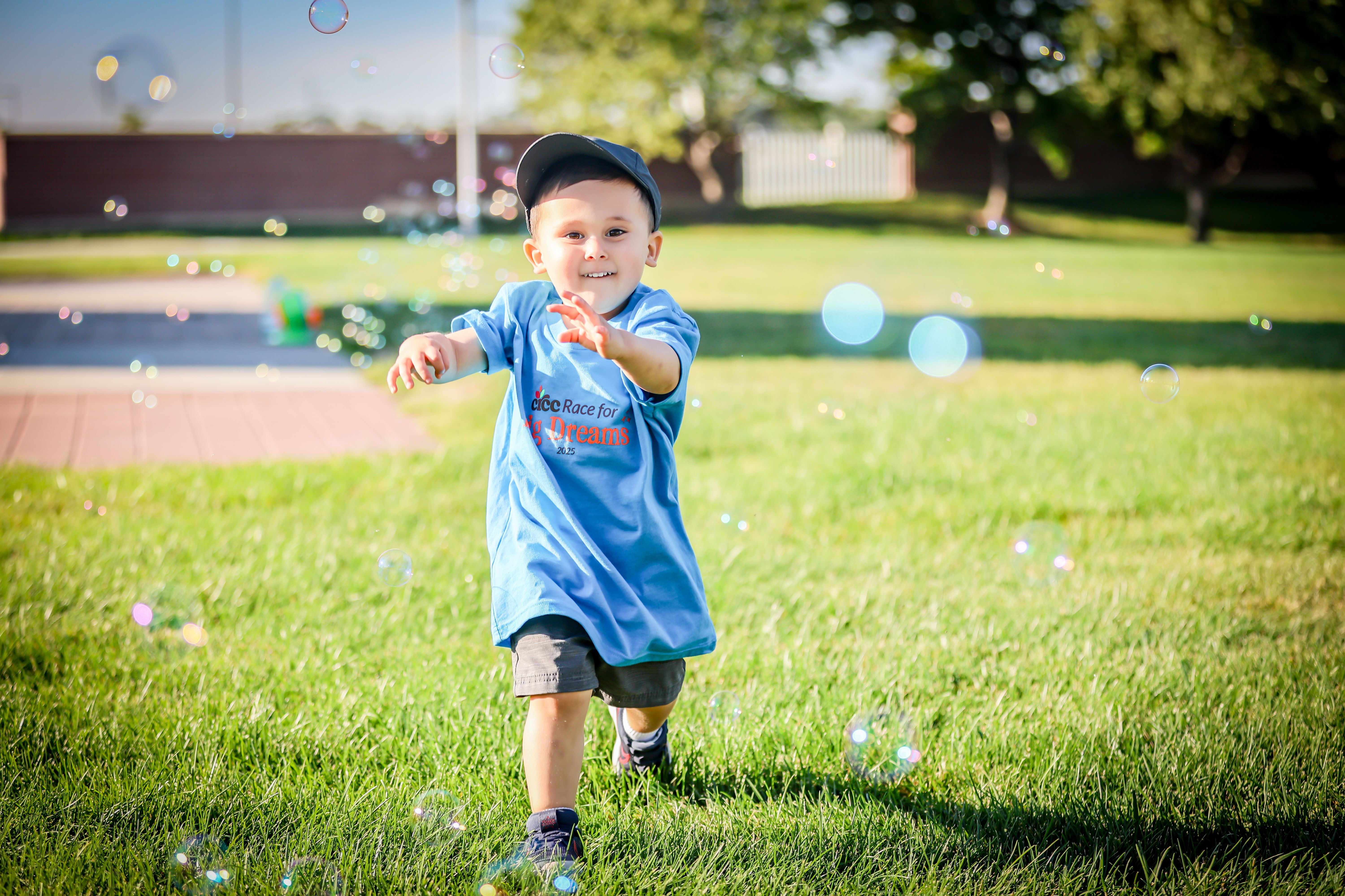 Boy chasing bubbles at the Race for Big Dreams