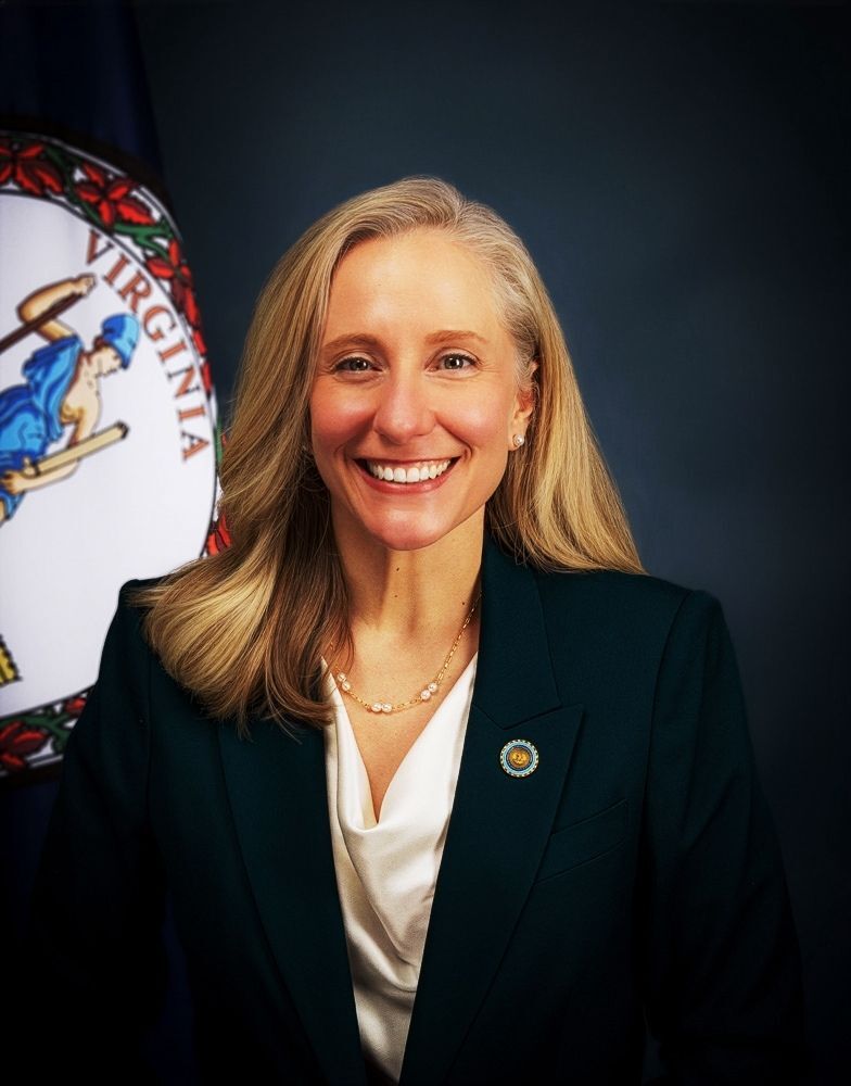 BP-1536A - Governor Spanberger next to a Wall  Plaque of the Great Seal of the State of Virginia