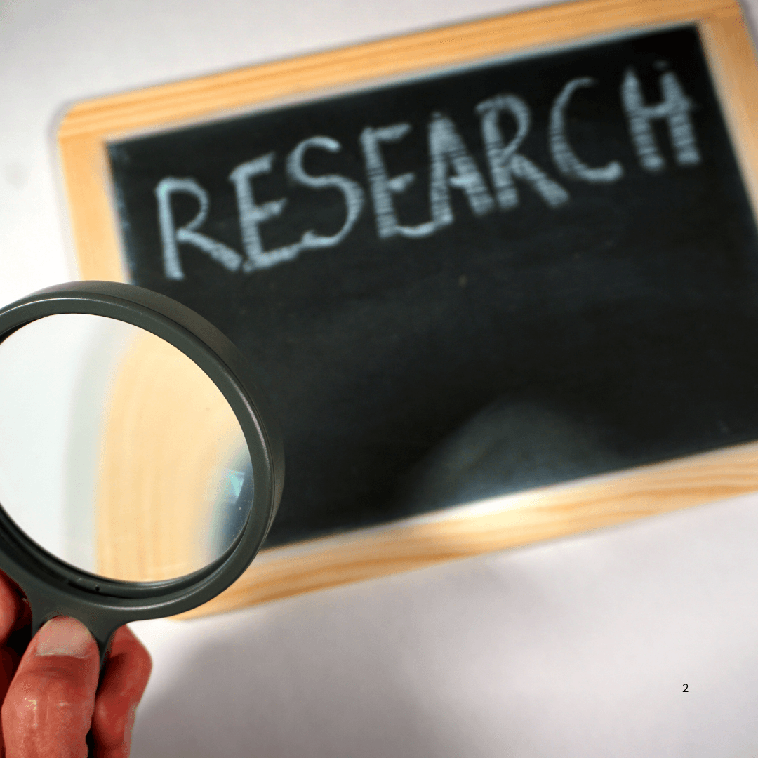 Research is written on a blackboard, as seen through a magnifying glass 