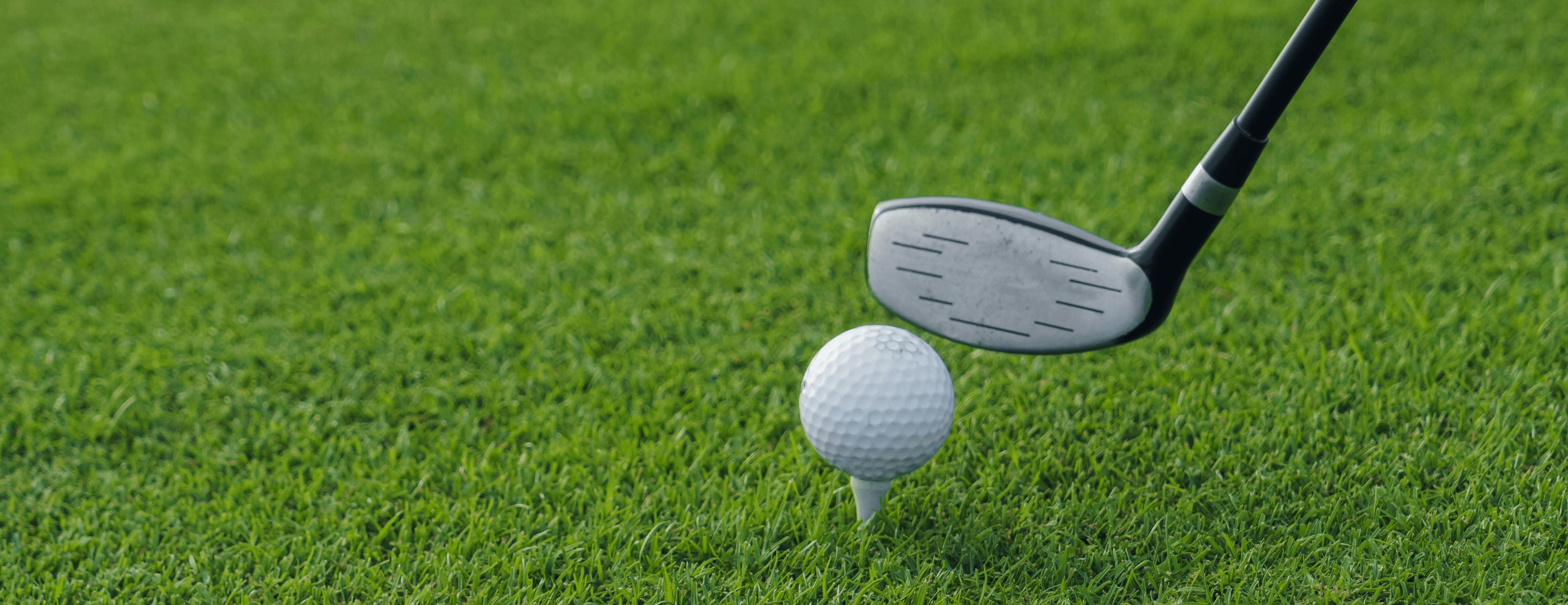 gloved hand placing golf tee on course