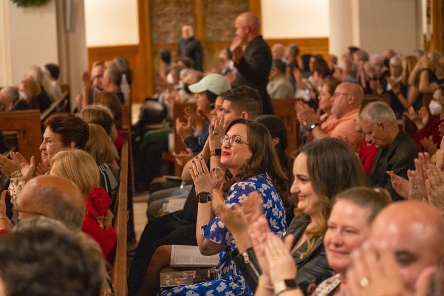 Audience members clapping and smiling.