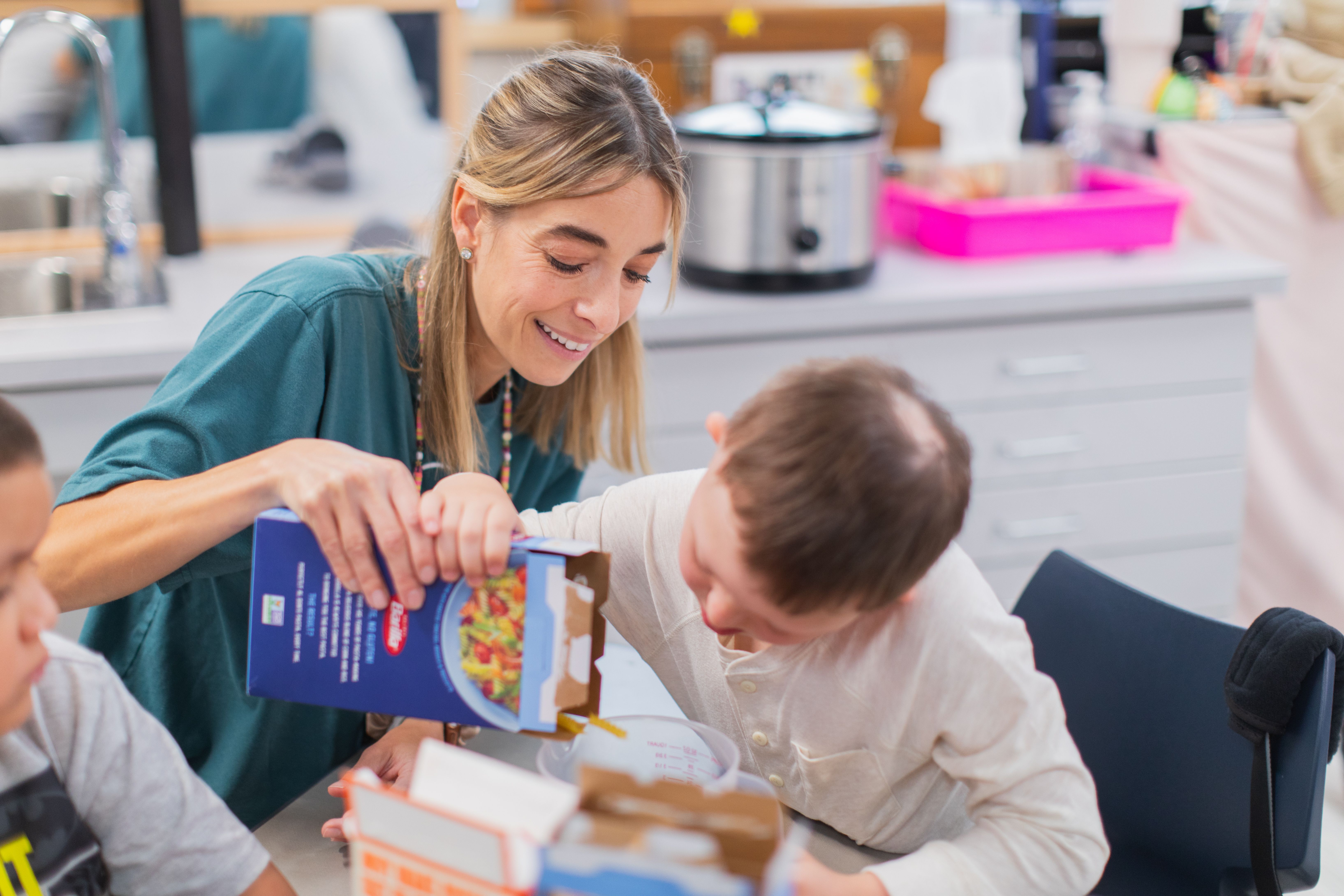 Steinwender helps student measure ingredients