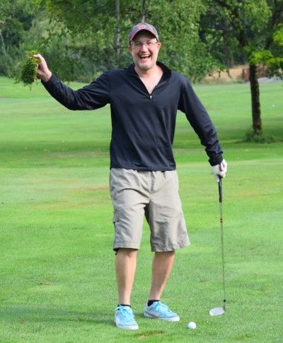 Jeff holds up clump of grass after his swing that misses the ball