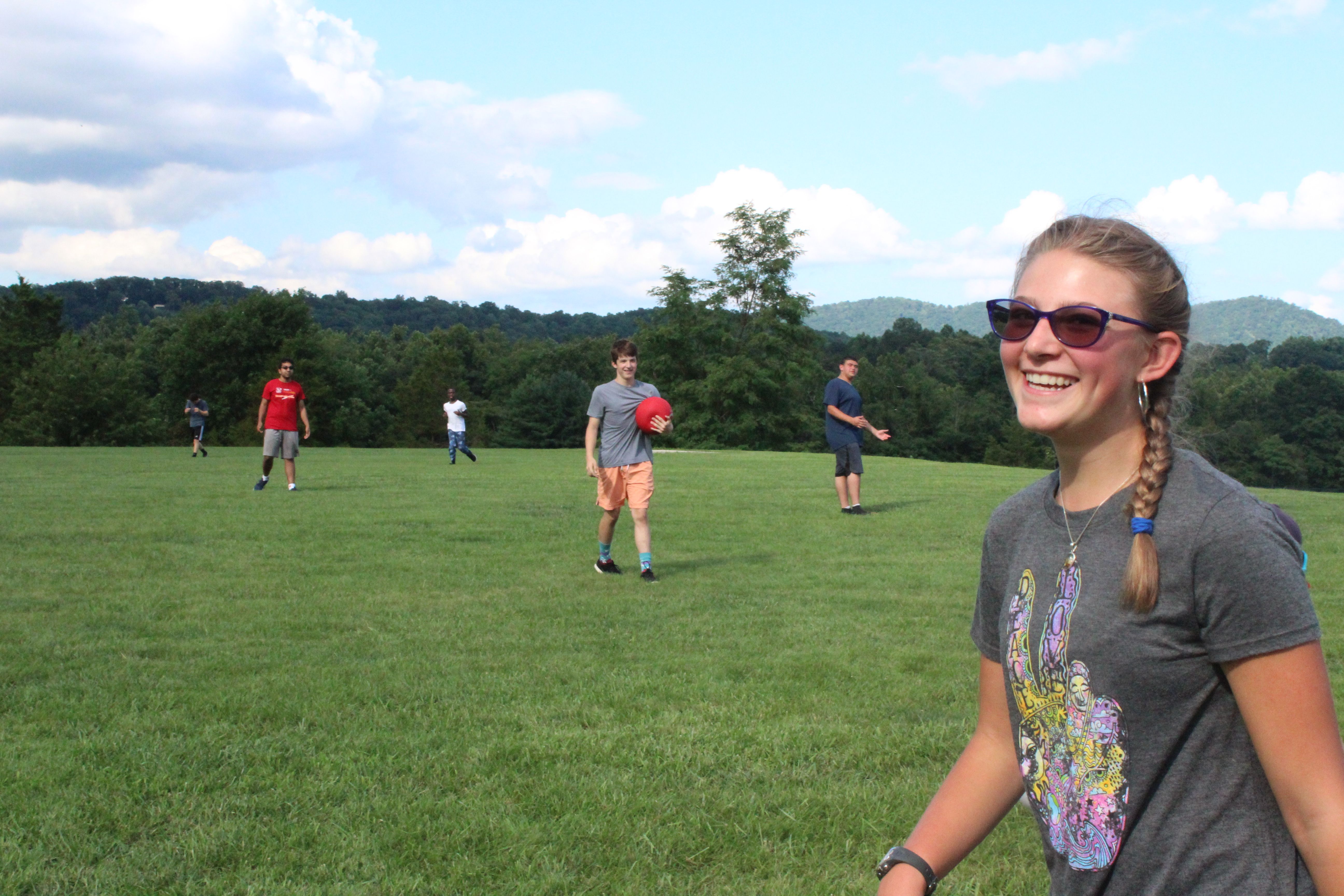 A camper smiles during a game of kickball.