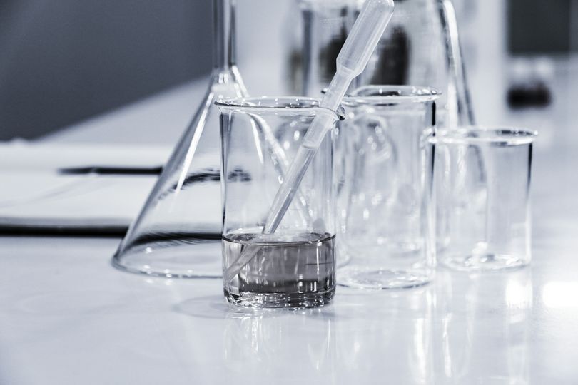 Blue gloved hands holding a small vial box