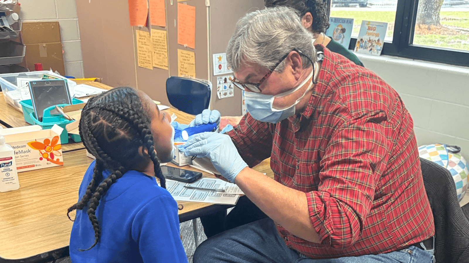 dentist providing dental screening to student