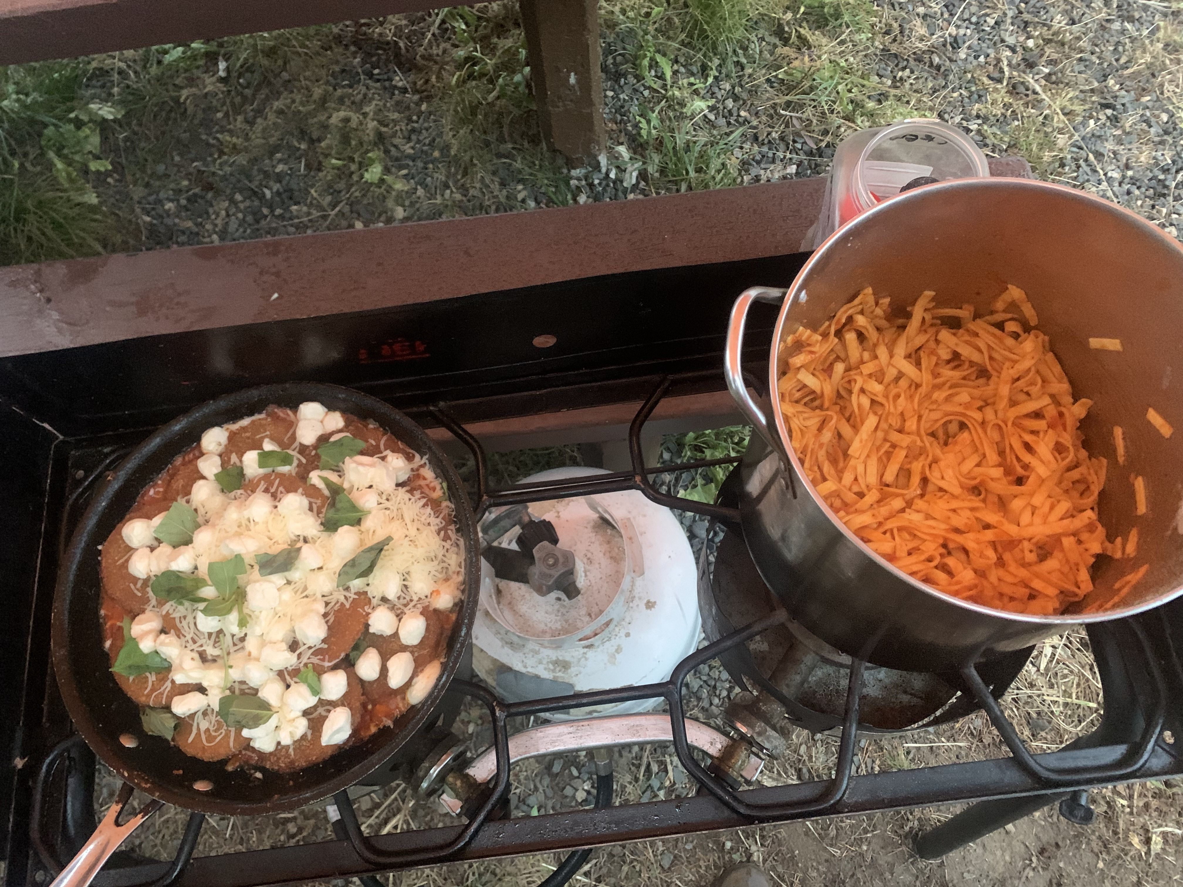 Pots of food sit on a propane stove