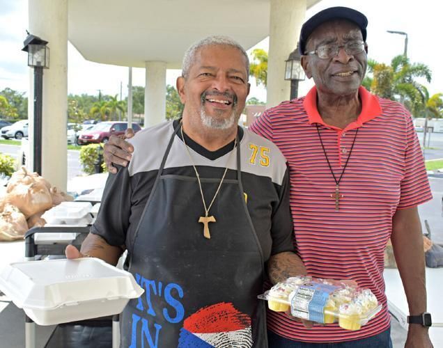 Luis Ramos, a Secular Franciscan order member and Knights of Columbus grand Knight, left, distributes food to those in need with Richard Eze.