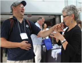 A picture of two people greeting each other at the usher syndrome conference.