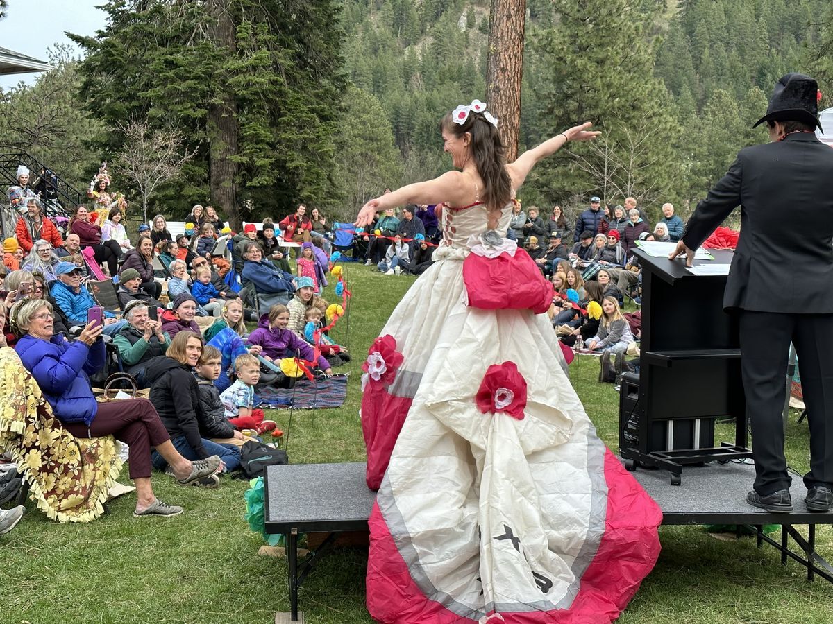 An image of a woman on stage with a pink and cream dress made out of an upcycled retired parachute.