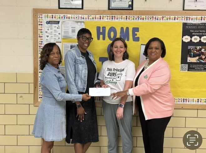 four women holding grant check