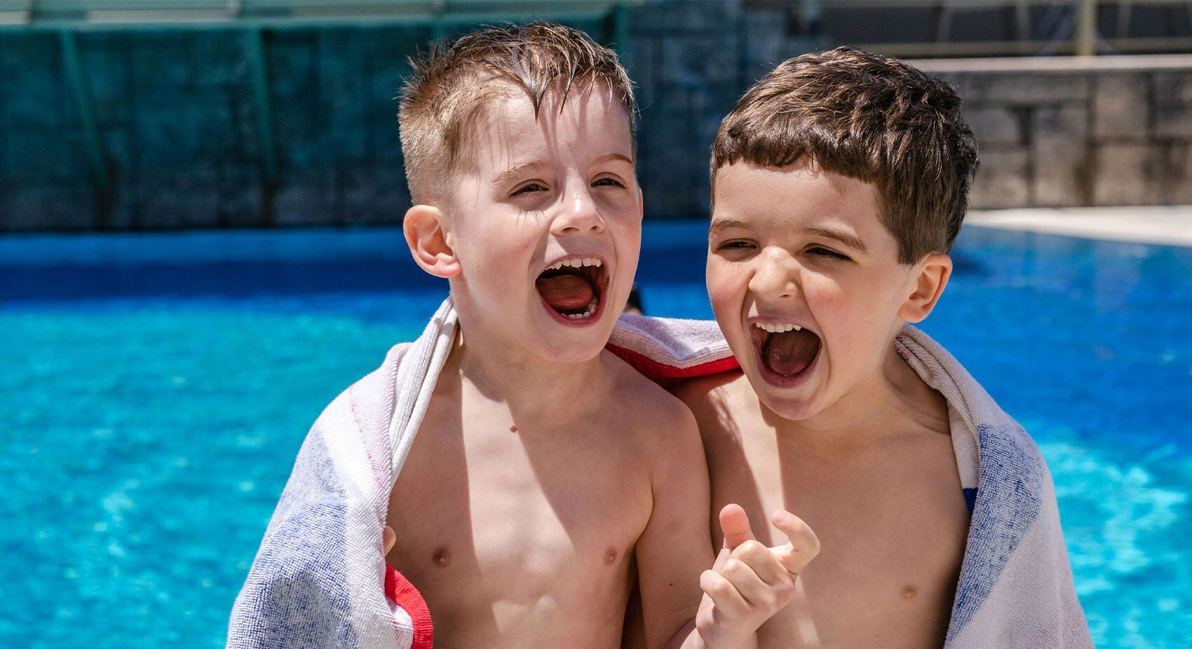 Two boys smiling at pool