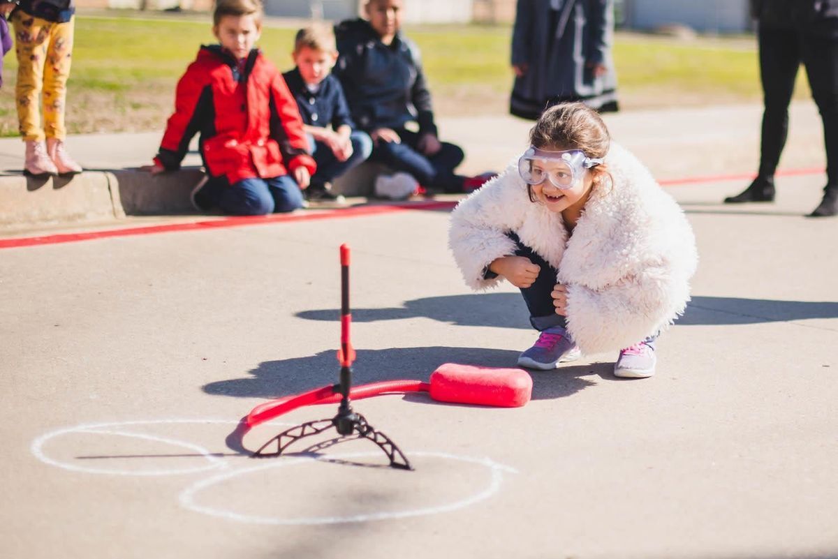 BB Owen Elementary student kneels down in front of a miniature propelled rocket, the materials provided for by LEF campus grants