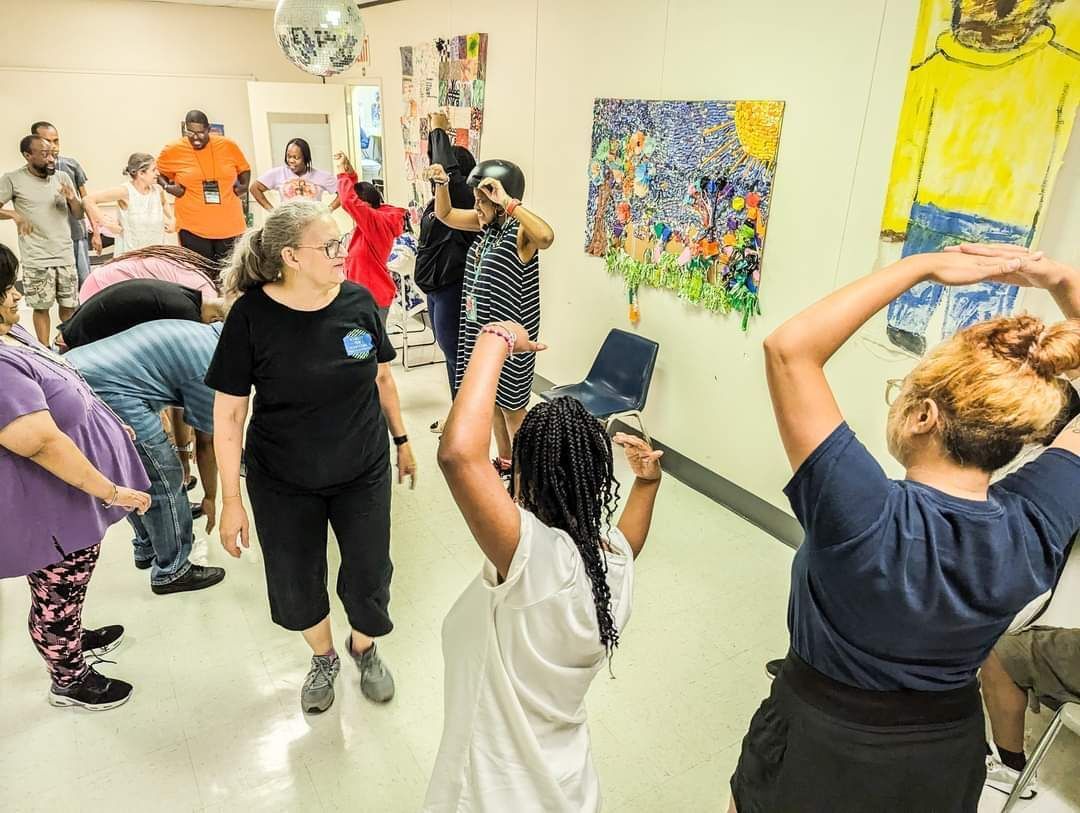 A photo of a woman instructing participants with IDD in an inclusive dance class