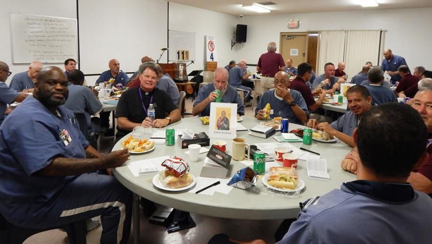 Deacon Greg Quinn, director of Catholic Charities' Prison Ministry program, second from left, sits at a table for lunch with inmates at a recent Rescate retreat near Indiantown