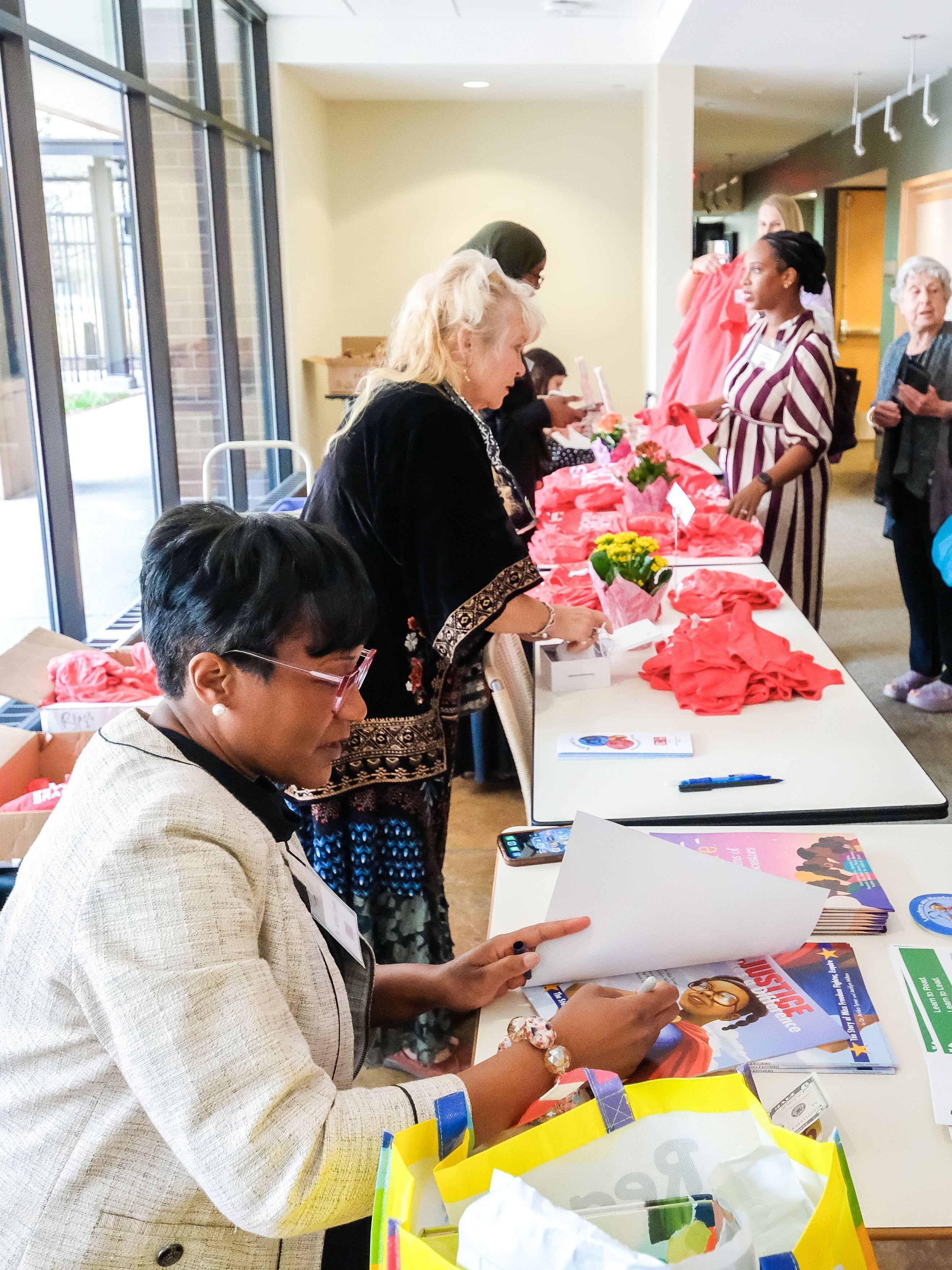 People at desk sign books and sell t-shirts to audience members