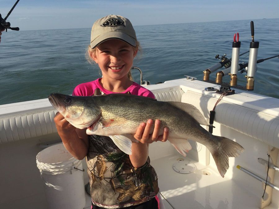 Young girl holding a walleye fish.