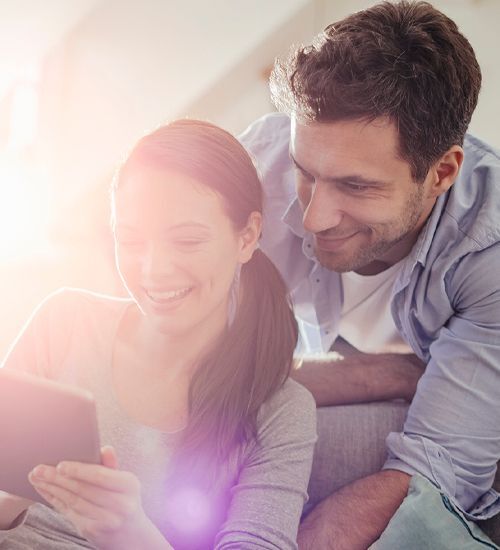 Happy couple looking at tablet