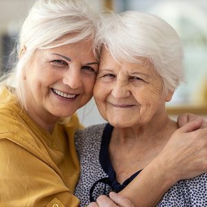 Older woman hugs her mother.