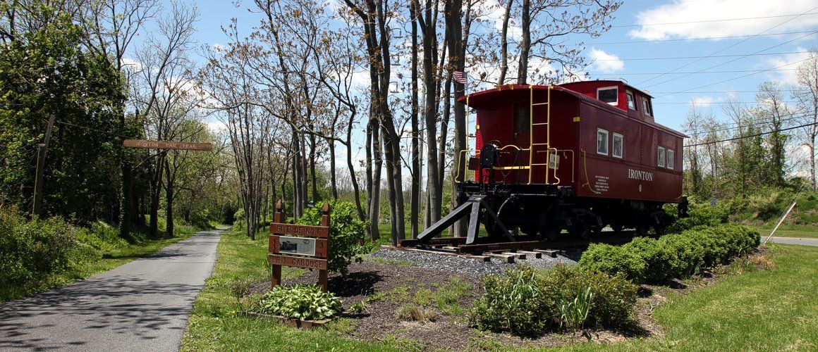 A train caboose sits alongside the Ironton Rail Trail as a Site of Note.