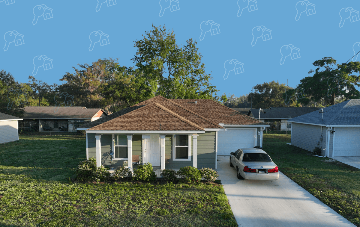 Completed Habitat for Humanity home in Pasco County, Florida, with a covered front porch, attached garage, and driveway.
