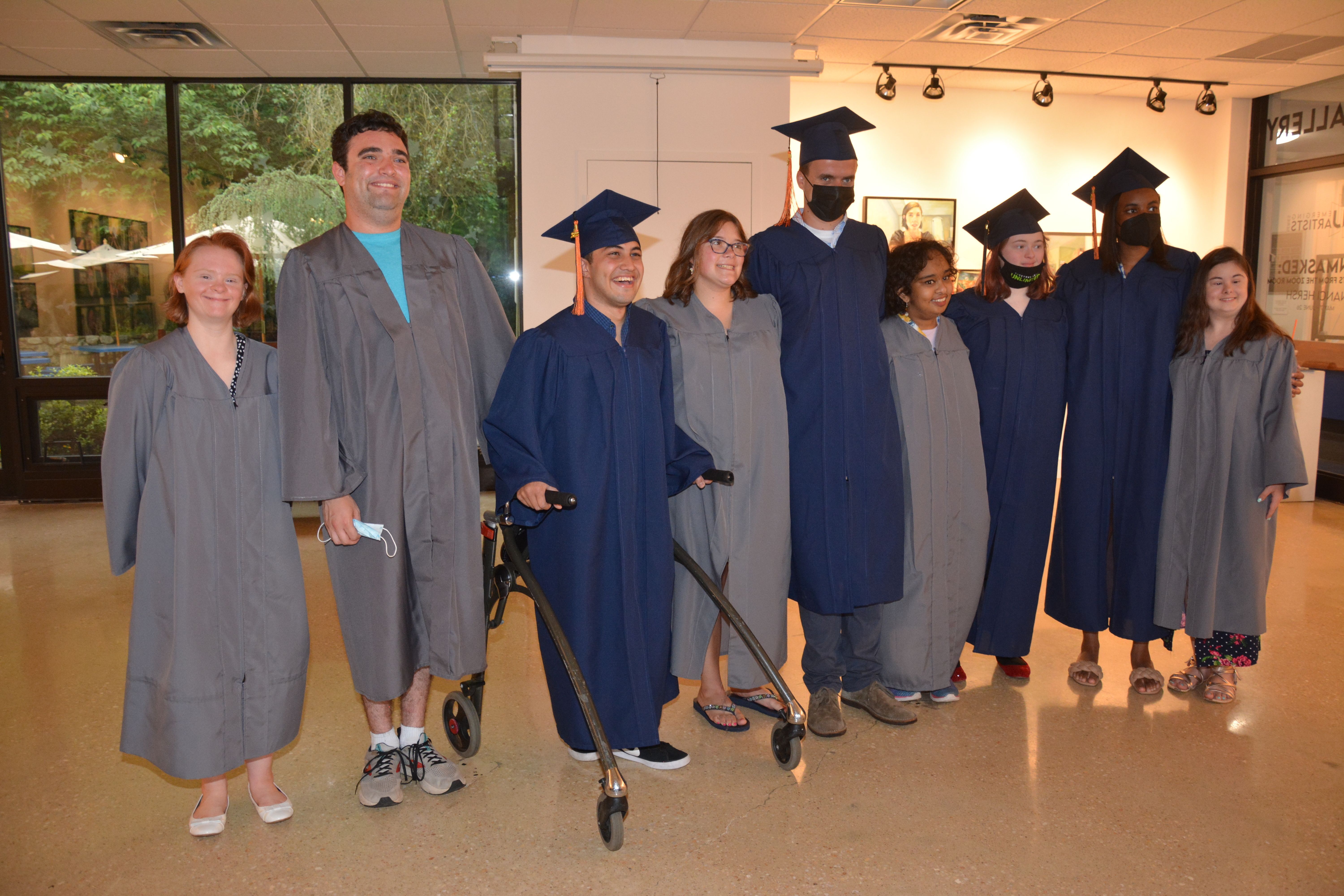 2020-2021 Kach Graduates stand in cap and gown on graduation day.