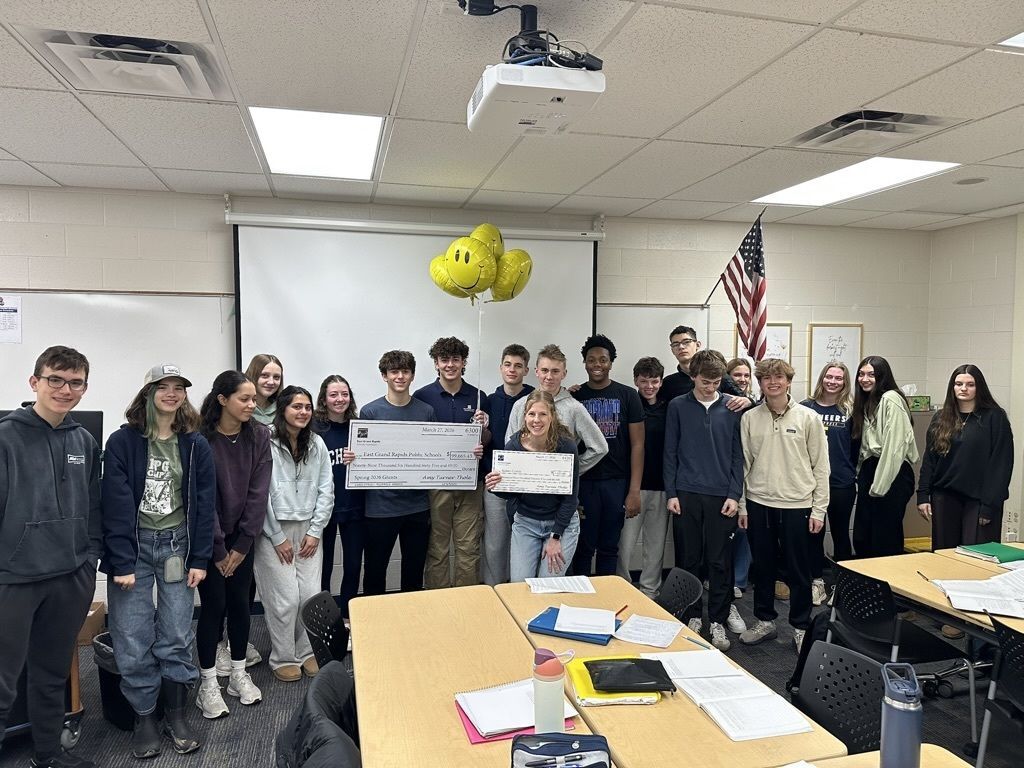 high school students and teacher Kelsey Curley with a big check