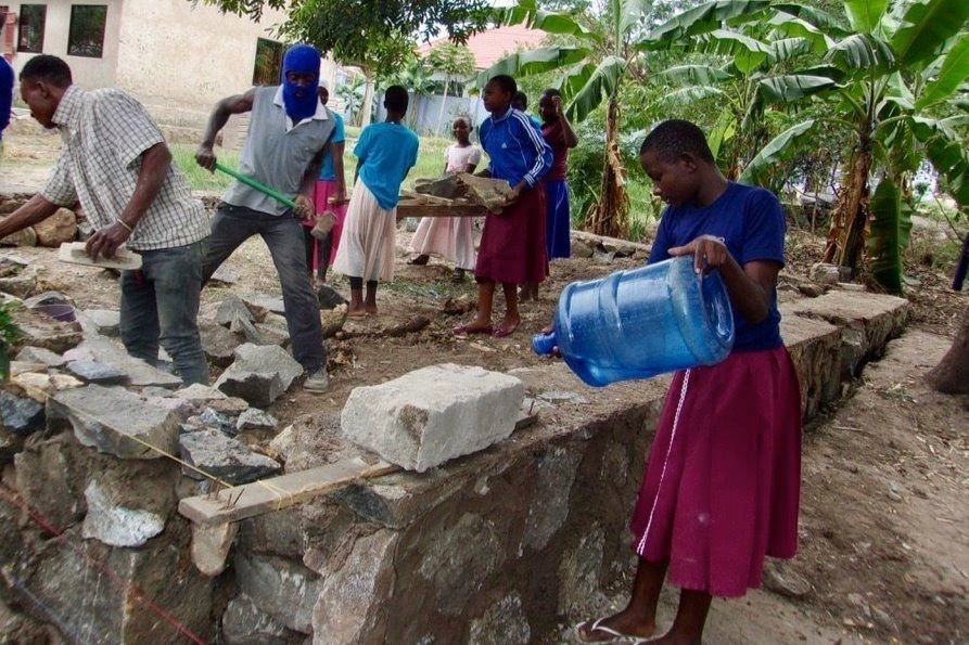 Students and adults learning how to prepare cement.