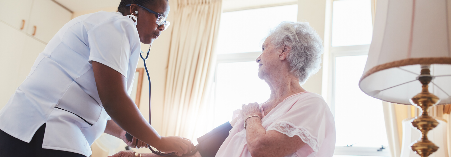 Nurse taking the pulse of an older woman