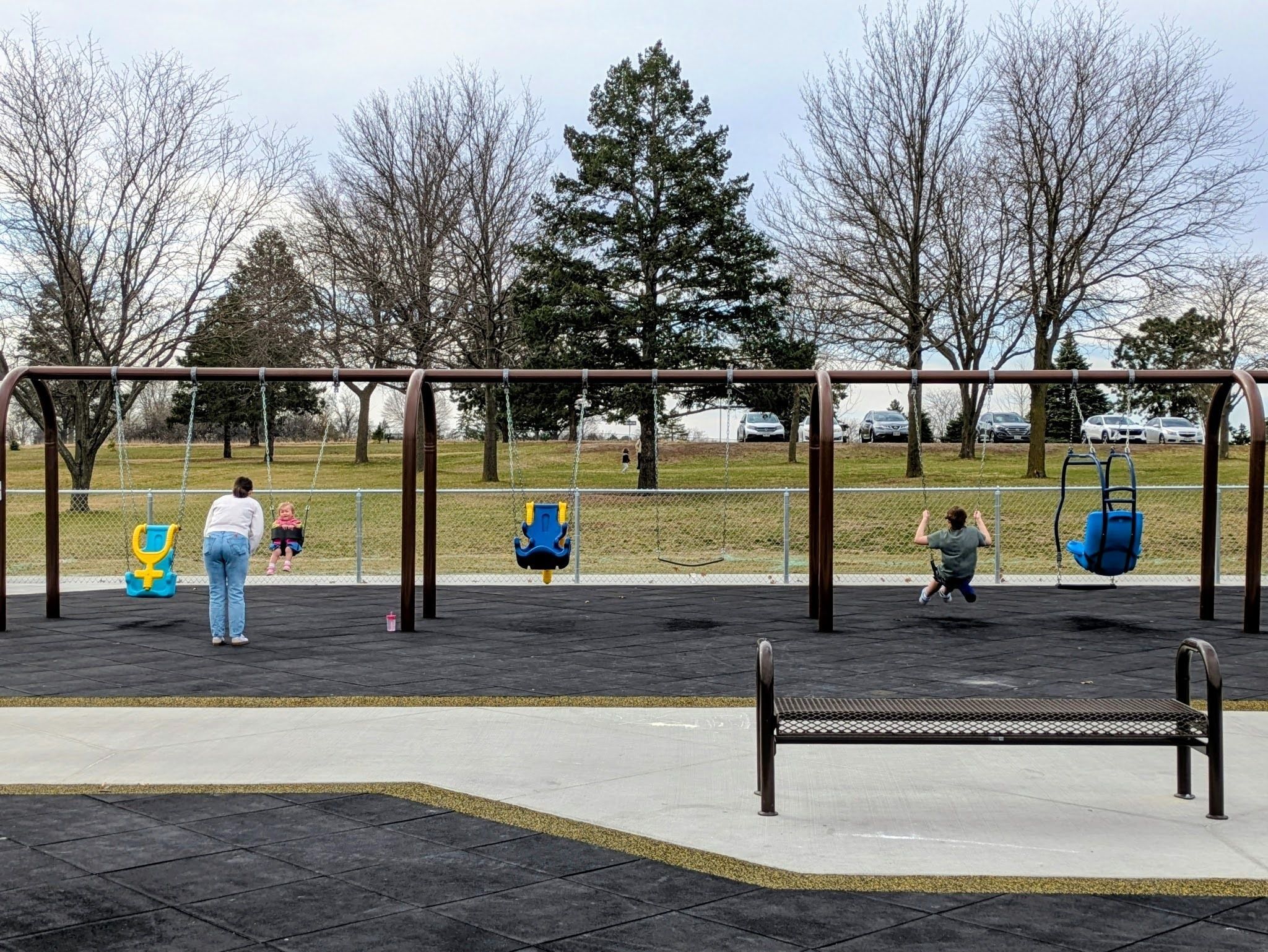 siblings and friends at Mahoney Inclusive Playground on the swings