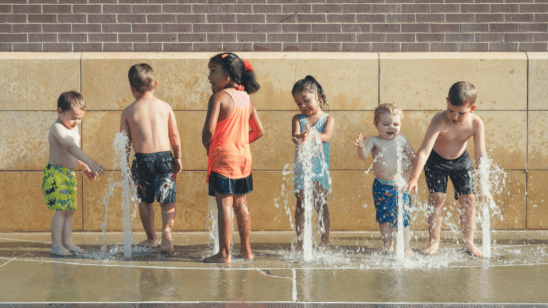 Photo showing children cooling off on a splash pad on a city street