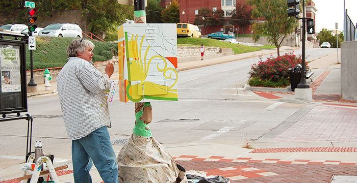 Grace McCammond painting the traffic box on 10th and Felix Street 