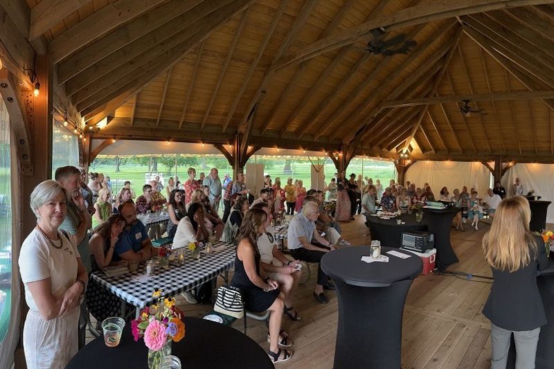 A well-dressed crowd gather around a dance floor in Snipes Farm and Education Center's new Outdoor Pavilion.