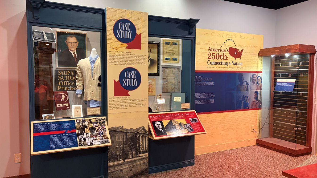 Exhibit display with three artifact cases and labeling in cream, red and blue colors.