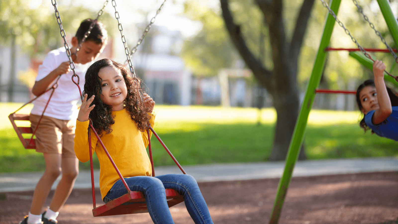 Three kids playing on swing set