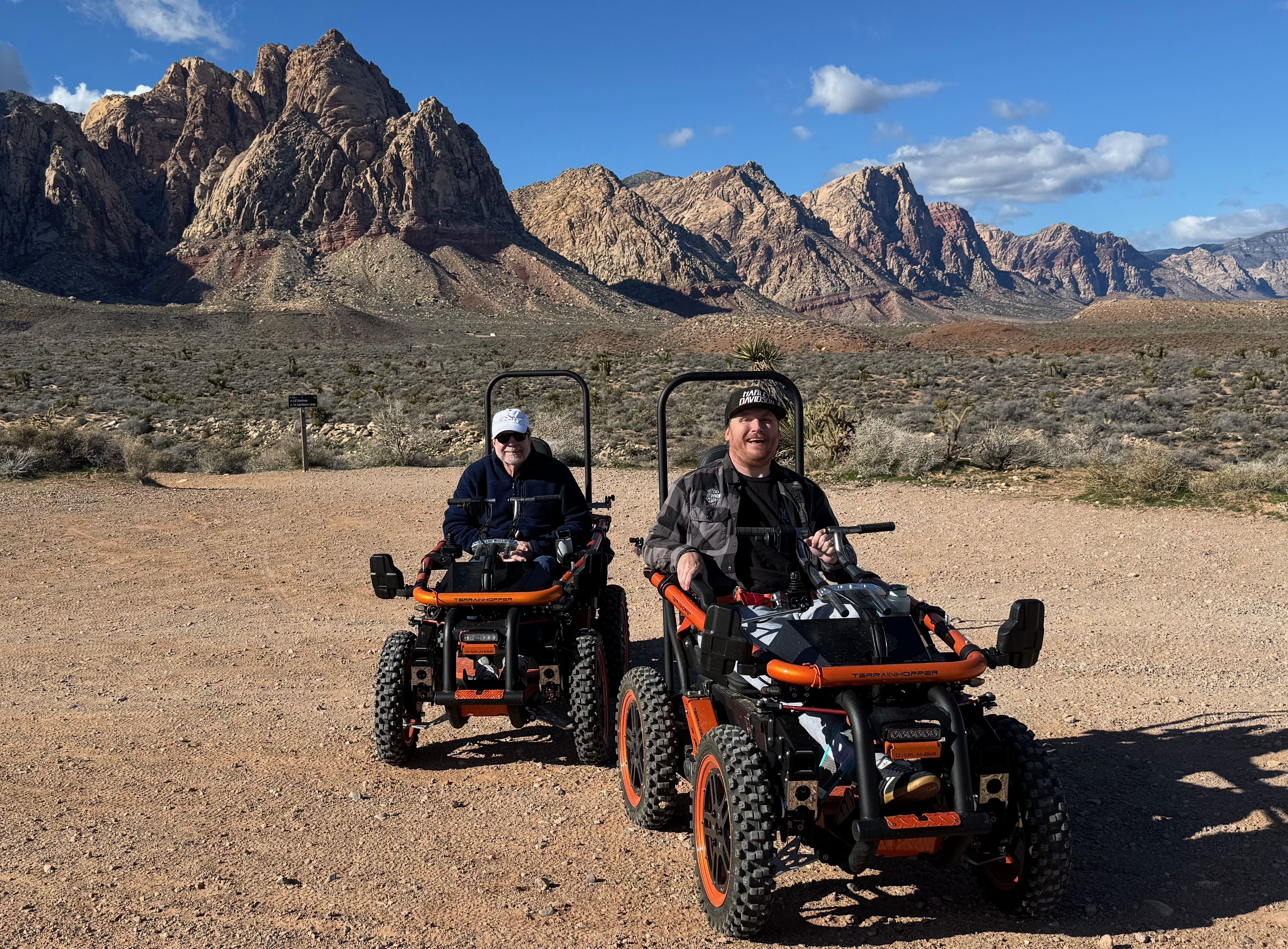 Rocky trail with view of Red Rock Canyon cliffs ahead and two TerrainHopper riders. 