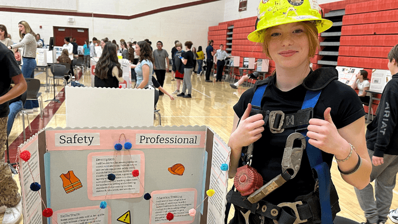Girl with hard hat in gym at school