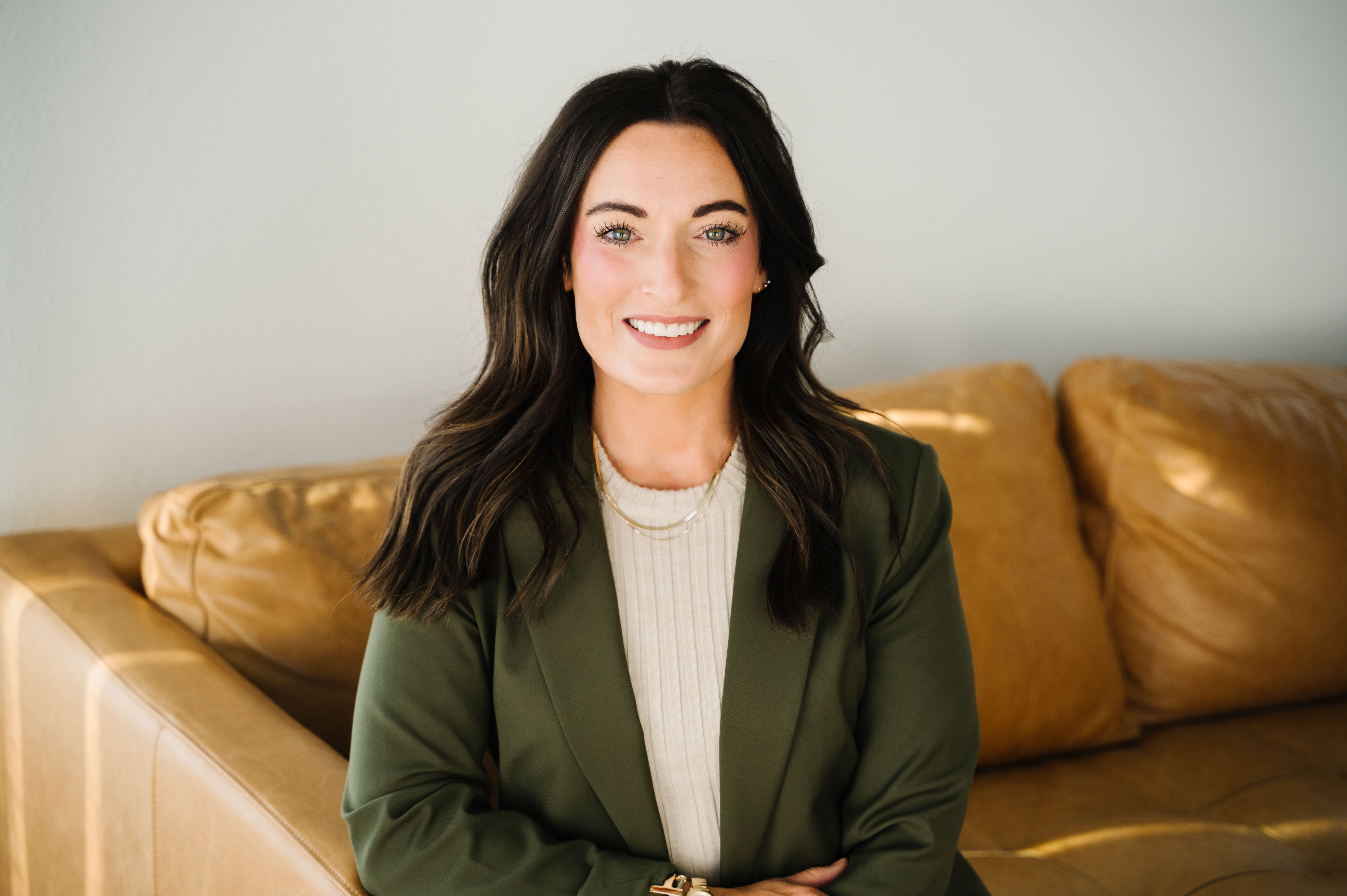 Paige Short, woman sitting on sofa, smiling