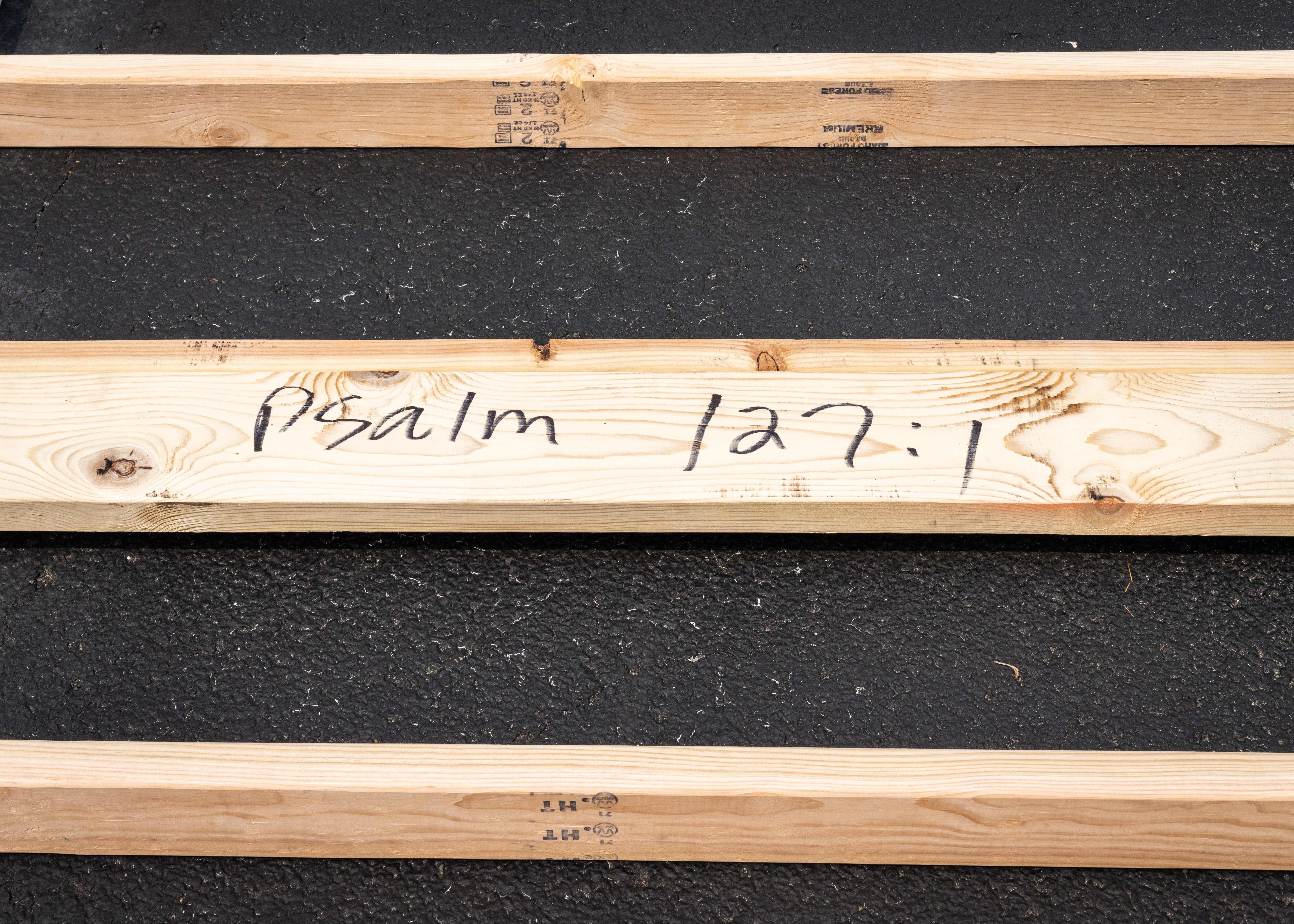 A stud of lumber reads "Pslam 127:15