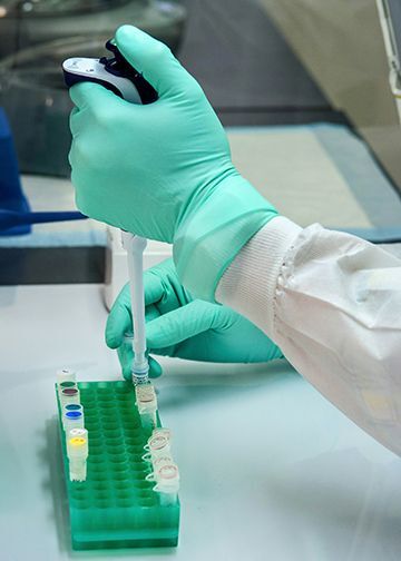 Hands working with test tubes in lab