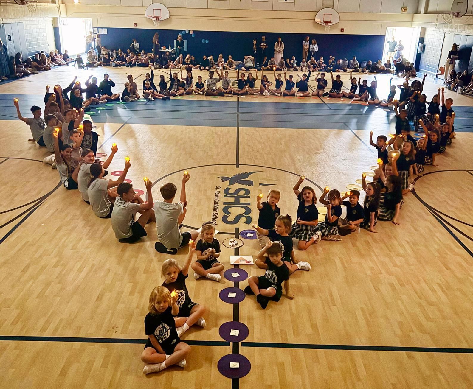Students at St. Helen in Vero Beach pray a "living rosary" in the school gymnasium on the feast of Our Lady of the Rosary
